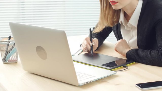 Woman designer working in office with graphic tablet
