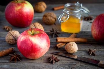 Naklejka na ściany i meble Apples, cinnamon, nuts, star anise on a wooden table. Baking.