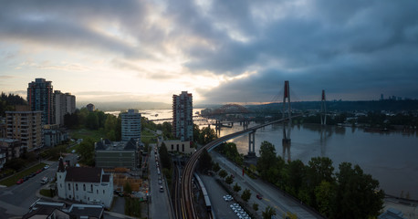 Fototapeta premium Aerial Panoramic view of Fraser River and Bridges during a vibrant sunrise. Taken in New Westminster, Greater Vancouver, British Columbia, Canada.