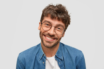 Obraz premium Isolated shot of positive bearded male with friendly smile, being in high spirit as spends free time with beautiful woman, pleased to recieve positive answer on propsal, stands against white wall