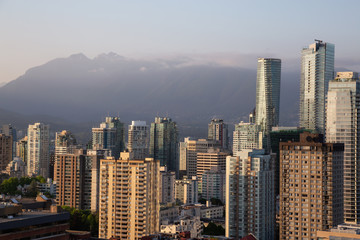 Aerial view of the Downtown City Commercial and Residential Buildings during a sunny sunset. Taken in Vancouver, BC, Canada.