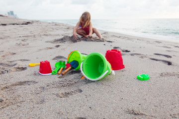 Fototapeta na wymiar kids toys and little girl playing on the beach