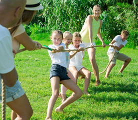 Kids with moms and dads playing tug of war