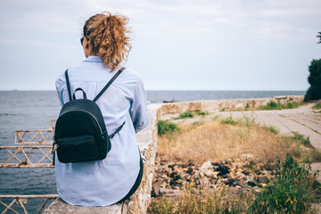 Fototapeta premium Rear view of young woman with backpack