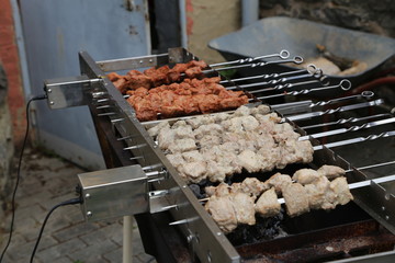 Shish kebabs rotate on the grill with electric motors