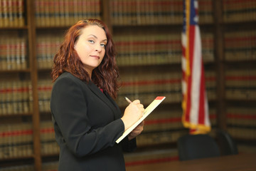 Portrait of an attractive redhead woman, woman lawyer in law library