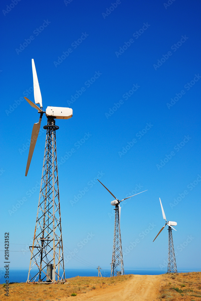 Wall mural wind power station against a clear blue sky