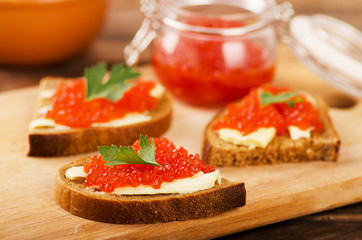 Red salmon caviar in sandwich and bowls