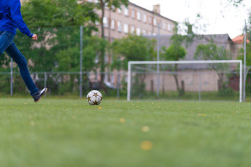 soccer ball with his feet on the football field