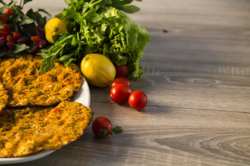 Lahmacun and organic vegetables on the wooden background for restaurant concept.