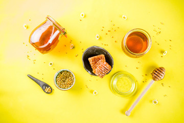 Organic floral honey, in jars, with pollen and honey combs, with wildflowers creative layout bright...