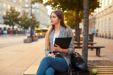 Fototapeta premium Pretty girl sit with her laptop on the city street