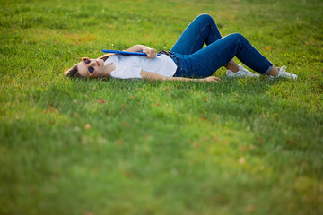 Pretty girl with her book in park background, sunset