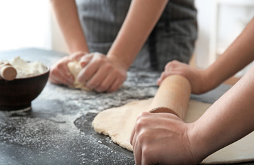 Obraz na płótnie Canvas Woman rolling dough on table, closeup