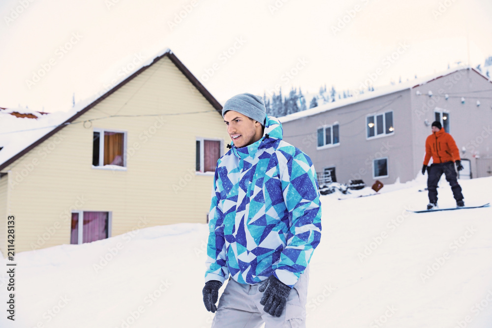 Sticker Handsome man at snowy ski resort. Winter vacation