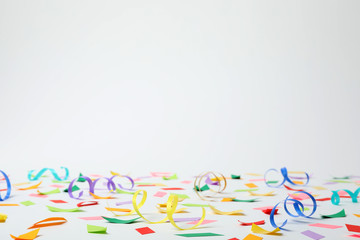 Colorful confetti and streamers on white background