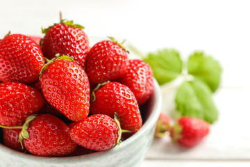 Bowl with fresh ripe strawberries on table, closeup