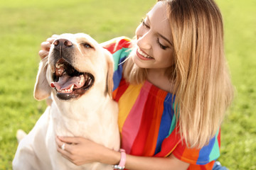 Cute yellow labrador retriever with owner outdoors