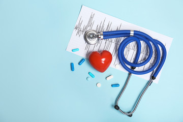 Stethoscope, cardiogram and pills on color background. Cardiology service