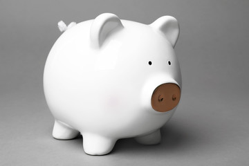 Cute white piggy bank on gray background