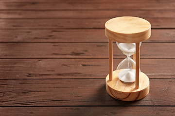 Hourglass with flowing sand on table. Time management