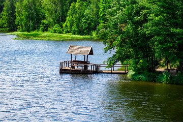 Relaxing gazebo built on the river against the forest