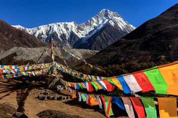Mount Gongga (also known as Minya Konka) - Gongga Shan in Sichuan Province, China. Tibetan Prayer Flags with Sacred Snow Mountain in the background. Himalayas, Highest Mountain in Sichuan Province