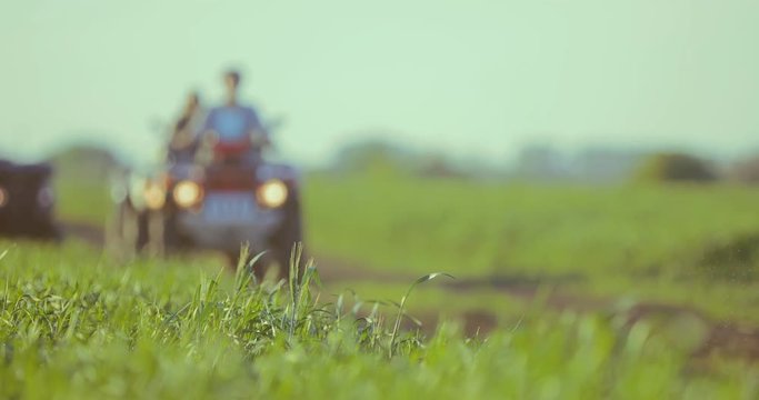 Company of friends on quad bikes in the field during sunset