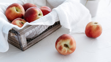 Peaches in basket on white linen