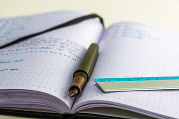 Naklejka premium Notebook with writing, ruler, pencil, fountain pen