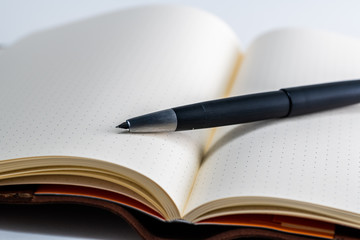 An open blank paper notebook with a classic vintage fountain pen