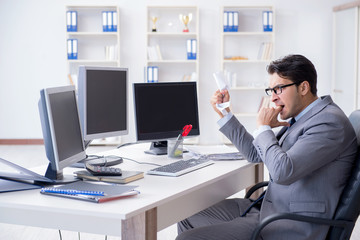 Businessman sitting in front of many screens