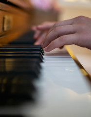Fototapeta premium A little girl practices at the piano