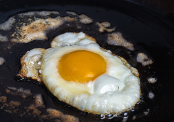 An fried egg in butter in a carbon steel frying pan