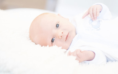 Awake Newborn with Eyes Open in Comfortable Sleeper Pajamas on a White Soft Blanket