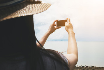 Young woman taking photo phone. She use mobile camera while travel vacation