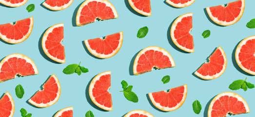 Halved fresh grapefruits on bright color background
