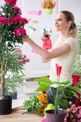 Young woman watering plants in her garden