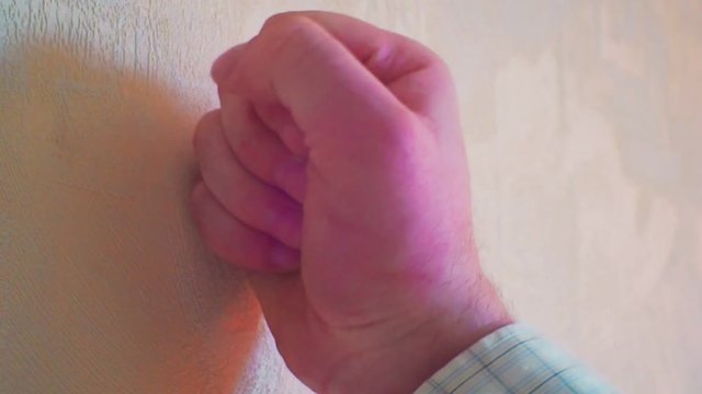male fist aggressively hitting the wall.