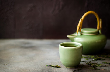 Chinese green tea in teapot on dark background