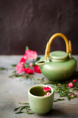 Chinese green tea with roses on dark background