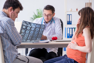 Fototapeta premium Pregnant woman with her husband visiting the doctor in clinic