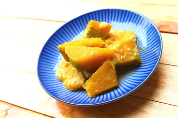 Fried pumpkins with egg in blue dish on wooden background
