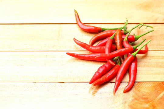 Fresh red chilies on wooden background