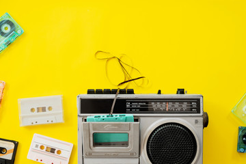 vintage radio and cassette player on yellow background, flat lay, top view. retro technology