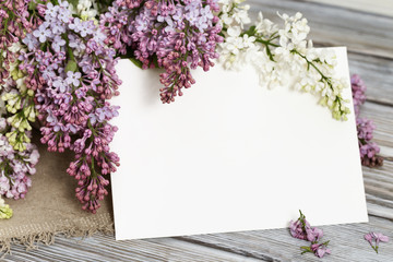 Greeting card with branch of lilac on wood. Rustic style. Copy space.