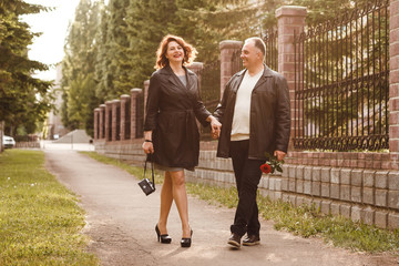 middle-aged married couple walking in the Park in summer, wedding anniversary