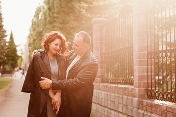 happy middle-age man and woman hugging outdoors, Sunset backlight in summer