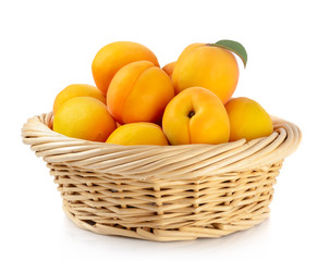 Fresh apricots in the basket are isolated on a white background.