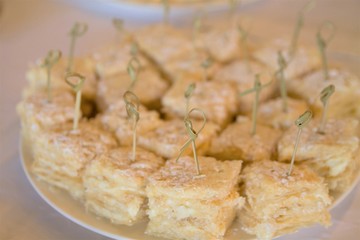 sweet delicious cake cut in pieces and laying on a plate with sticks stuck in them